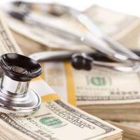Stethoscope Laying on Stacks of Hundred Dollar Bills with Narrow Depth of Field. Stethoscope Laying on Stacks of Hundred Dollar Bills with Narrow Depth of Field.