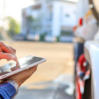 Truck drivers hand holding tablet containing electric log Truck drivers hand holding tablet containing electric log