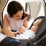 Mother Putting Baby Son in rear-facing car seat
