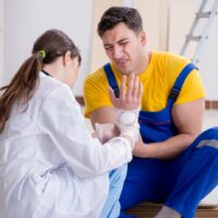 Injured worker being assisted by doctor Injured worker being assisted by doctor