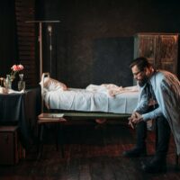 Male visitor against empty hospital bed Male visitor against empty hospital bed