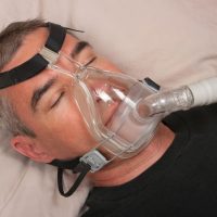 Man with sleep apnea and CPAP machine Man with sleep apnea and CPAP machine