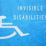 invisible disabilities concept. text next to icon of person in wheelchair with blue background