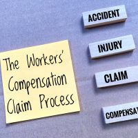 The Workers' Compensation Claim Process message on sticky notes and four blocks labeled with Accident, Injury, Claim, and Compensation.