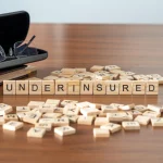 wooden-tiles-spelling-underinsured-are-arranged-neatly-on-a-table