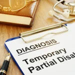 a-clipboard-with-a-document-titled-diagnosis-temporary-partial-disability-lies-on-a-wooden-desk